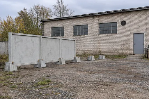 Панельный бетонный забор на опорах. Забор в процессе монтажа. Панели на отдельных опорах у ремонтного склада. Визуализация.